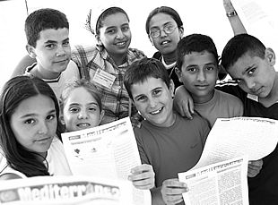 Niños marroquíes y españoles muestran algunos ejemplares de la revista que han confeccionado.
