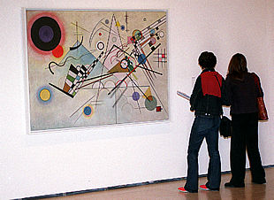 Dos visitantes, ante la primera obra de Kandinsky que adquirió Solomon R. Guggenheim para su colección:  Composición 8   (1923) 