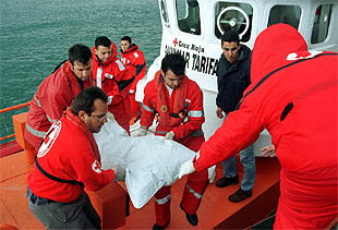Miembros de Cruz Roja Española de Tarifa (Cádiz) rescatan del mar el cadáver de un inmigrante.