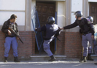 Policías argentinos echan abajo la puerta de la sede de un partido de izquierda donde se habían refugiado varios manifestantes el pasado 26 de junio.