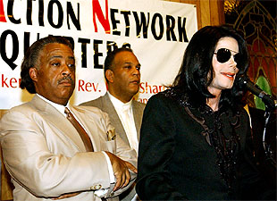 El reverendo Al Sharpton, a la izquierda, escucha a Michael Jackson el sábado en Harlem.