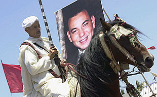 Uno de los jinetes participantes en los espectáculos de  fantasía,  junto a un retrato de Mohamed VI.