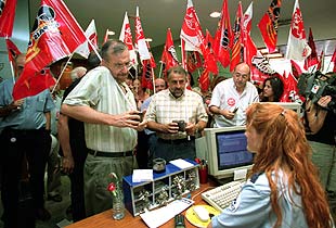 Los dirigentes de CC OO y UGT, Joan Sifre y Rafael Recuenco, muestran sus carnets para acceder al Servef, con los manifestantes a sus espaldas.