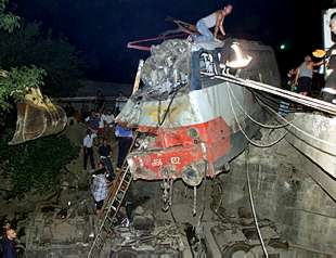 Varias personas buscan víctimas en el interior de la locomotora del tren accidentado.