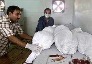 Médicos palestinos amortajan los cuerpos de tres niños, encontrados ayer en los escombros de las casas destruidas por el ataque sobre Gaza.