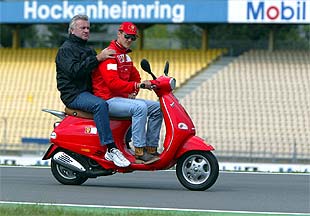 Schumacher y su    manager,  Willi Weber, inspeccionan ayer en moto el circuito de Hockenheim.
