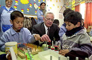 Paul O'Neill juega con unos niños durante su visita a un comedor comunitario de la periferia de Buenos Aires.
