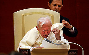 El Papa es ayudado a recolocarse su capa, levantada por el viento, ayer, durante el rezo del   ángelus   en Castel Gandolfo.