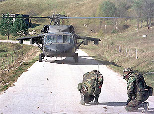 Dos  cascos azules  de EE UU se protegen durante el aterrizaje de un helicóptero de la OTAN en Bosnia.