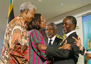 Nelson Mandela y su esposa, Graça Machel, saludan a Thabo Mbeki en presencia de Kofi Annan, ayer en Johanesburgo.