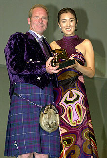 El director Peter Mullan recoge el León de Oro de manos de la actriz Gong Li, presidenta del jurado de la Mostra. PLANO MEDIO - ESCENA
