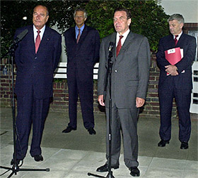 Chirac y Schröder hablan con la prensa ante la mirada de sus ministros de Exteriores, De Villepin y Fischer.