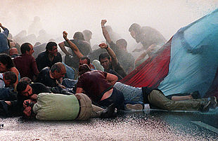 Unos manifestantes resisten a la carga de la policía vasca con agua a presión contra la marcha de Bilbao.