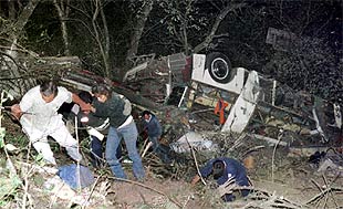 Los equipos de rescate ayudan a salir a algunos pasajeros supervivientes del autobús accidentado. PLANO GENERAL - ESCENA