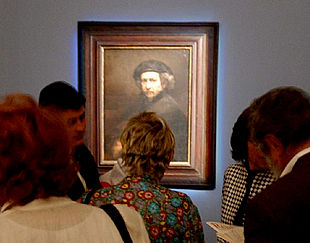 Unos visitantes contemplan un autorretrato de Rembrandt.