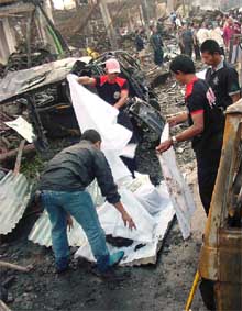 Agentes de policía cubrían ayer el cuerpo de una de las víctimas del atentado contra el Sari Club, en Bali.