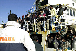 Un policia italiano vigila un barco con más de 400 inmigrantes ilegales en el puerto de Catania.