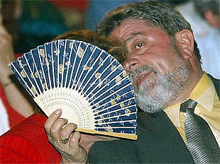 La esposa de Lula se cubre con un abanico para conversar con su marido durante una reunión en Río de Janeiro.