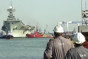 Dos trabajadores de Izar observan el atraque del  Príncipe de Asturias , ayer, a su llegada a Cádiz.