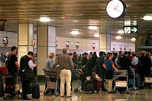 Un grupo de pasajeros guarda cola, el jueves, para facturar su equipaje en el aeropuerto de Barajas.