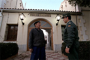 Un vecino conversa con un guardia civil frente a la casa cuartel de Mondéjar (Guadalajara).