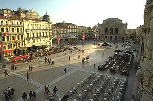 Terrazas de cafés y al fondo l'Opéra Comédie, uno de los teatros más grandes de Francia, en la Place de la Comédie en Montpellier.