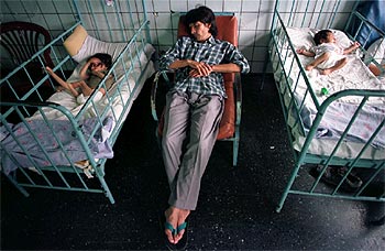 Pablo Francisco Gómez duerme junto a sus hijos, Pablo Enrique y Juan Facundo, en un hospital de Tucumán.