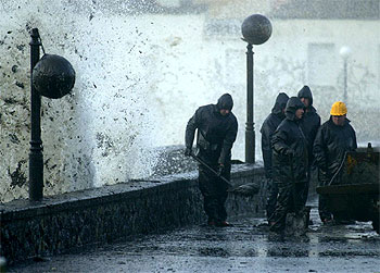 Limpieza del fuel vertido por el petrolero    Prestige  en el paseo marítimo de la localidad coruñesa de Muxía.