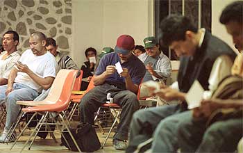 Varios inmigrantes esperan para obtener unas tarjetas de identificación en la Casa del Migrante situada en Tijuana (México).