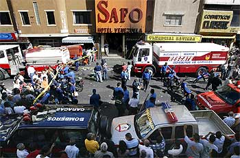 La policía y los bomberos  inspeccionan el club La Guajira, que ardió el sábado por la noche en el centro de Caracas.
