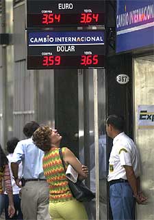 Una ciudadana consulta los valores ante una oficina de cambio.