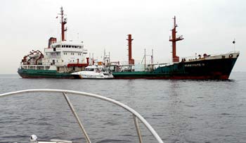 El  Anastasios IV , ayer, fondeado en aguas de Algeciras y custodiado por una patrullera de la Guardia Civil.