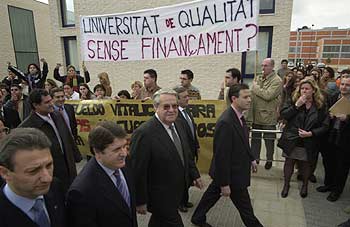 El presidente Olivas, a la izquierda, con el rector Francisco Toledo, ayer, ante las pancartas y los universitarios que le abuchearon.