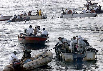 Decenas de personas tratan de recoger manchas de fuel a la altura de las islas Cíes.