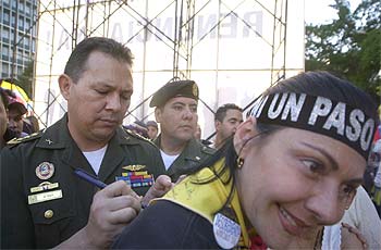 El coronel Aguedo Rogelio d'Hoy firma un autógrafo a una oponente al presidente venezolano Chávez.