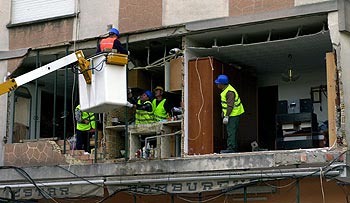 Varios operarios apuntalan el edificio cuya fachada se derrumbó sobre la terraza de una pizzería en Sueca.