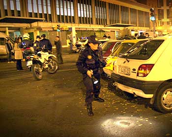 La policía, anoche, en el momento de registrar la zona del tiroteo en busca de casquillos de bala.