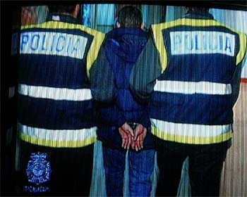 Dos agentes escoltan a uno de los detenidos en una imagen tomada del vídeo grabado por la policía.