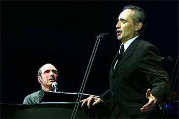 Lluís Llach al piano, a la izquierda, y José Carreras, en un momento del recital que ofrecieron en el Palau Sant Jordi.  SUSANNA SÁEZ