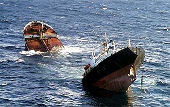 El petrolero    Prestige,  abierto por una de sus planchas y roto en dos, se hunde frente a las costas gallegas.