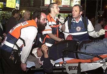 Miembros de un equipo de emergencia introducen en una ambulancia a uno de los heridos en el atentado de ayer en Tel Aviv.