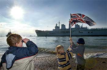 Un grupo de niños observa la partida del puerto de Portsmouth del portaaviones británico   Ark Royal   con destino al Mediterráneo.