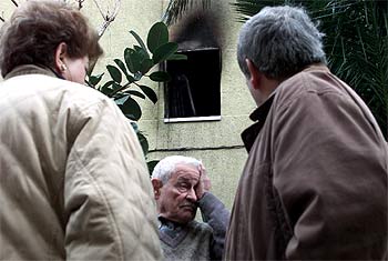 Tres personas, en el exterior de la vivienda siniestrada, en el barrio de La Florida de L'Hospitalet.