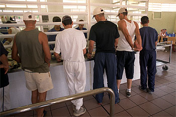 Varios presos hacen cola en el comedor del centro penitenciario de Aranjuez (Madrid).