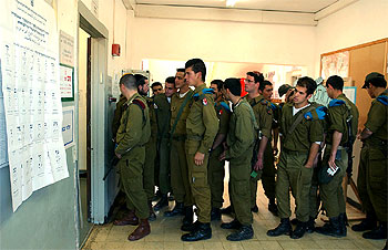 Soldados israelíes hacen cola para votar anticipadamente en la base de Gush Etzion, ayer, en Cisjordania.