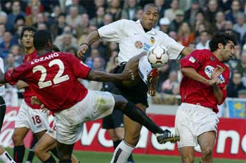 Carew intenta llevarse la pelota entre Lozano y Niño.