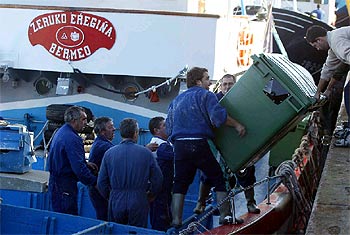 Varios pescadores se preparan para comenzar la recogida de fuel ayer en el puerto de Bermeo.