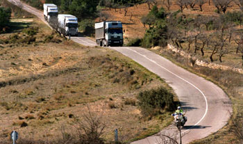 Un motorista de la Guardia Civil abre paso, ayer por la tarde, a los camiones a su paso por la aldea de Los Herreros.