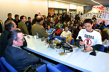 El ministro Piqué, en la Universidad Pompeu Fabra, donde aparecen pancartas contra la guerra y el  Prestige .