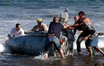 Miembros de la Guardia Civil y voluntarios sacan del agua los restos del fuselaje del F-18.